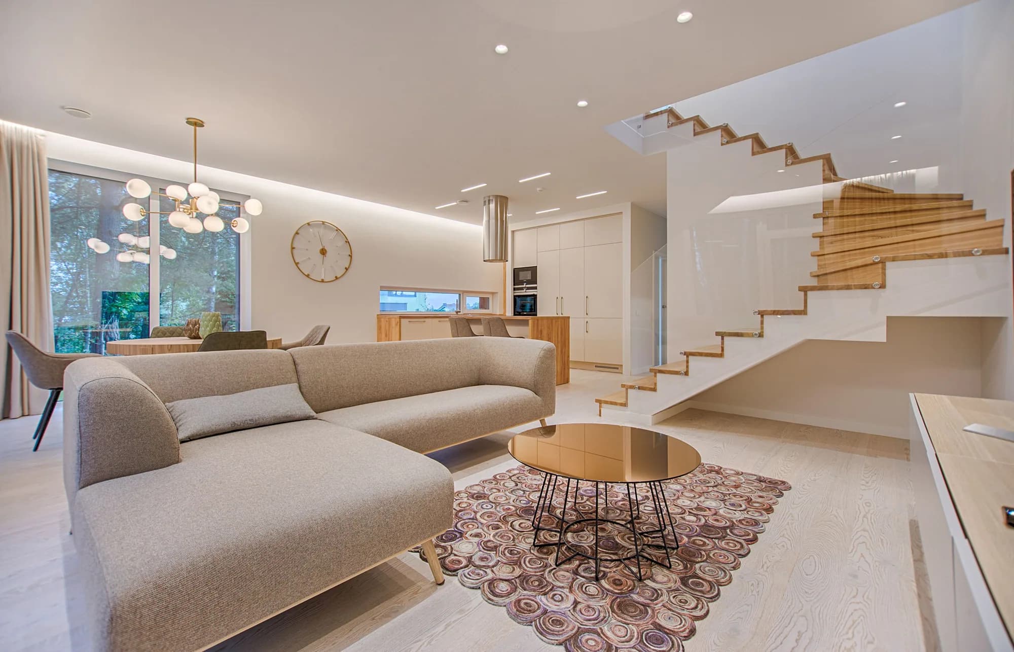 Contemporary living room with neutral sofa and stair volume — design inspiration